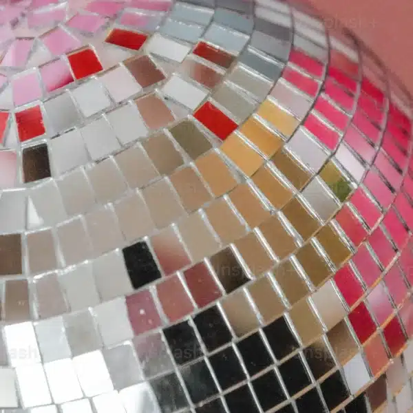Primer plano de una colorida bola de discoteca con azulejos reflectantes.