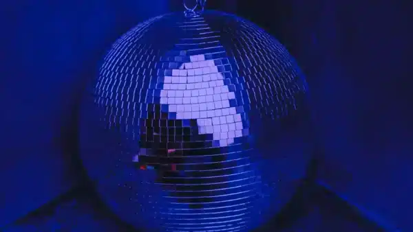 Primer plano de una bola de discoteca iluminada con luz azul.