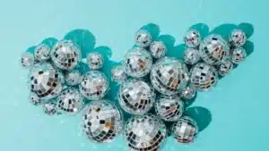 Cluster of disco balls reflecting light on a turquoise background.