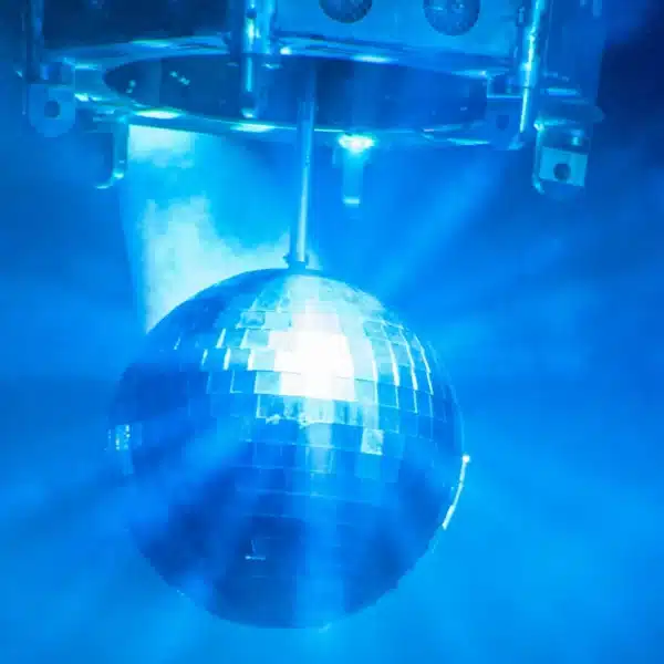 Una bola de discoteca que refleja la luz azul en una habitación llena de humo.