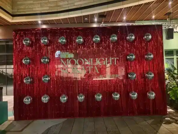 Un fondo rojo con el texto "Moonlight Sonata", rodeado de hileras de bolas de discoteca.