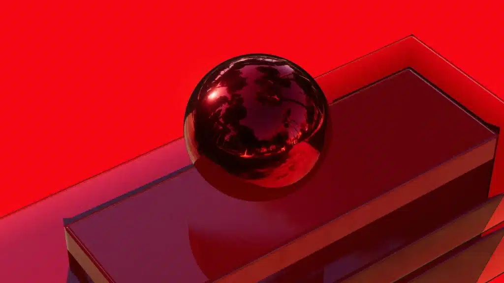 A shiny red sphere sitting on a reflective red surface, surrounded by a bold red background.
